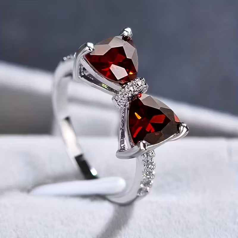 Pierścionek z szmaragdem w kształcie kokardy